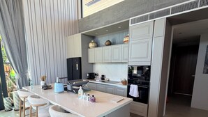 Uma cozinha moderna com uma ilha central, banquetas e eletrodomésticos embutidos.