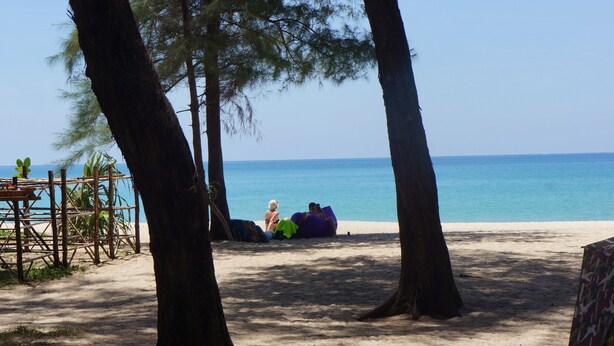A beach scene with a wooden structure, a sandy area, and a clear blue sea. - BRAND-NEW LUXURY VILLA IN THE BOTANICA FORESTIQUE RESIDENCE IN PHUKET, NEAR THE GOLF COURSE (Choeng Thale)