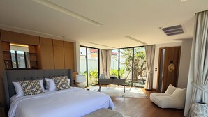Um quarto moderno com uma cama grande, um espaço de estar e vista através de amplas janelas.