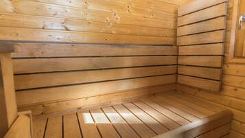 Un sauna en bois avec des lattes horizontales, un banc et une porte.