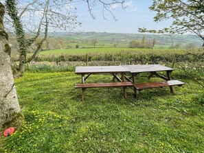 A picnic table in a grassy field with a view of rolling hills in the background. - All on the Ground Floor: 
Open plan living space. (Yarcombe)