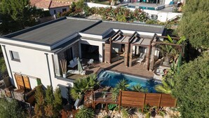 Ein modernes Haus mit Dachterrasse, Schwimmbad und Garten.
