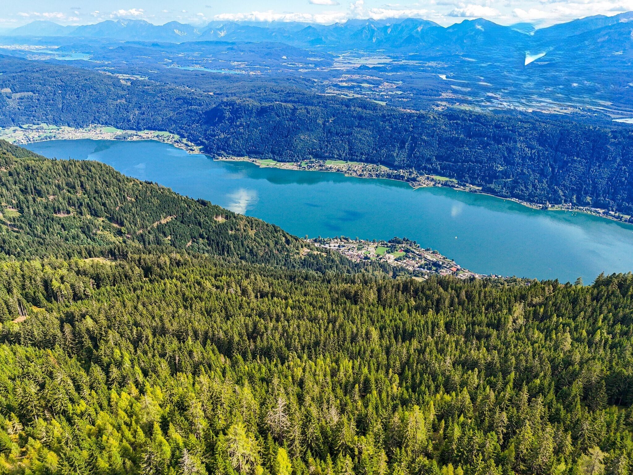 A mountainous landscape with a lake and forested areas.