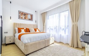 Un dormitorio moderno con una cama grande, una mesita de noche, un escritorio y una ventana con cortinas.
