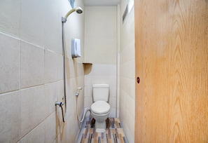 Un baño pequeño y estrecho con inodoro, ducha y secador de manos.