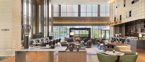 A spacious lounge area with seating arrangements, a bar, and large windows offering views.