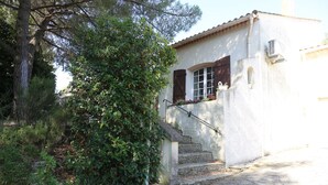A stone staircase leading to a white building with a tiled roof and wooden shutters. - Country House (Saint-Drézéry)
