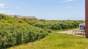 Et landligt landskab med en bygning, der har et saddeltag og en murstensstruktur.
