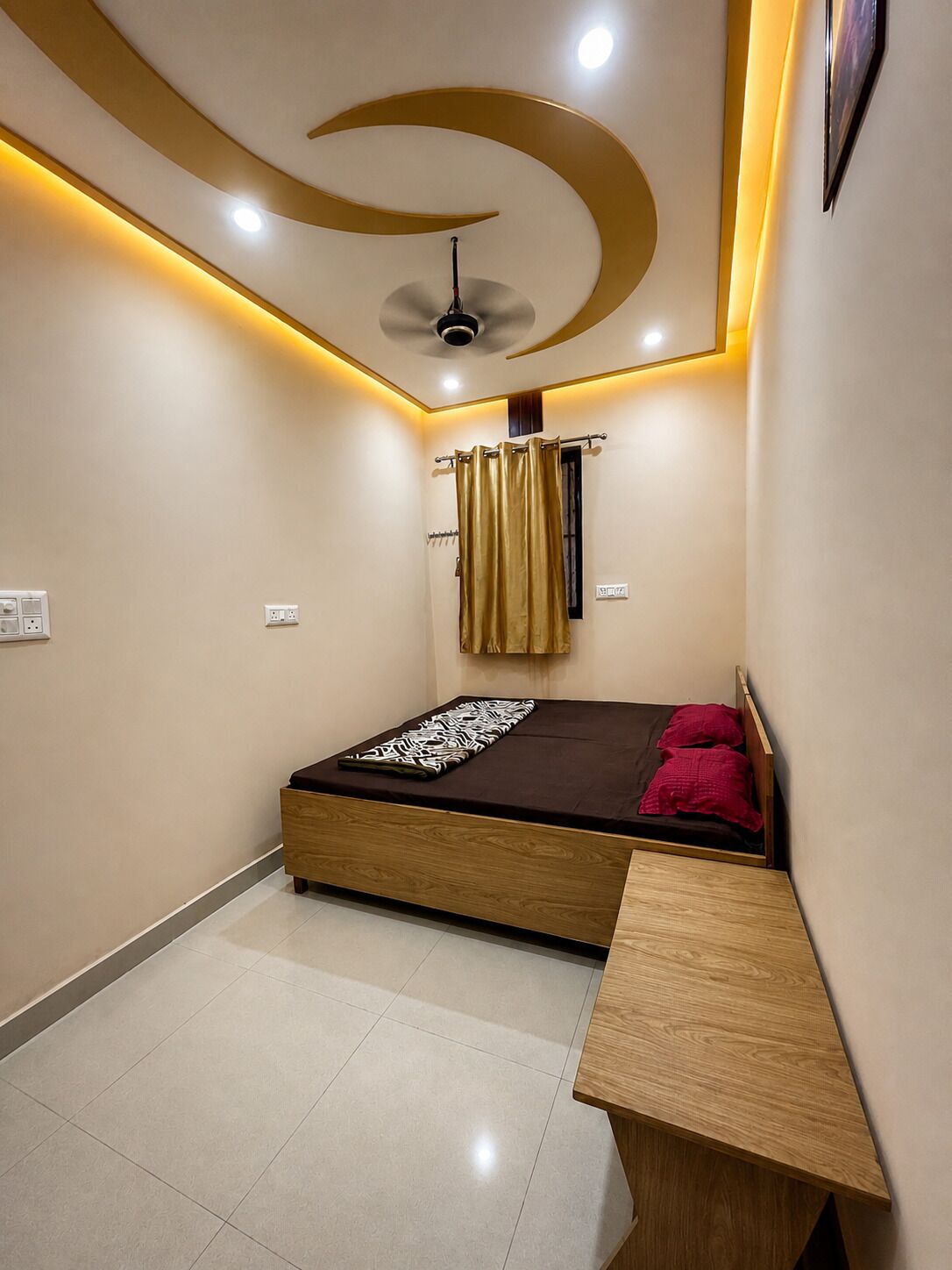 Ein Schlafzimmer mit einem Bett, einem Deckenventilator, einem Nachttisch und einem an der Wand montierten Fernseher.