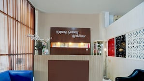A reception desk with a sign reading 'Kupang Gunung Residence,' a blue sofa, and patterned wall decor. - Cozy Double Escape W/ Free Wifi and Parking (Surabaya)