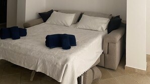 A bedroom with a bed, pillows, a clock, and a wall with framed pictures. - Cozy and modern apartment (Pagliadiccio)