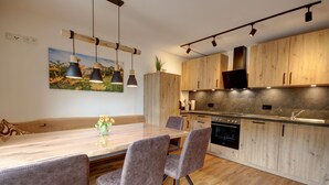 A modern kitchen with wooden cabinets, a marble countertop, and pendant lighting. - "Zuhaus" Vacation Rental on the 1st Floor, 70 square meters (Siegsdorf)