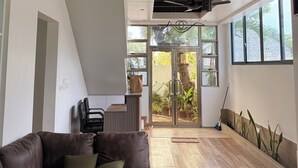 A modern interior with a sectional sofa, a ceiling fan, and large windows.