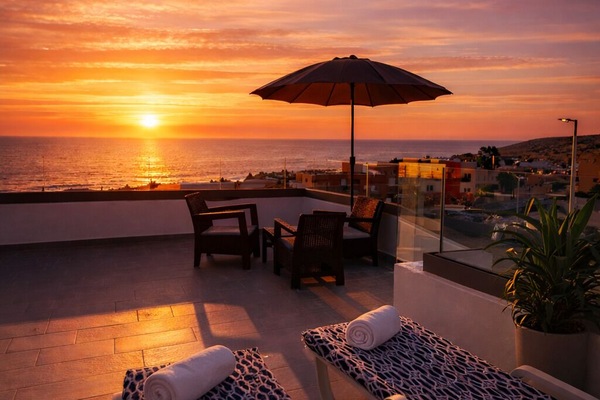 Ocean-view rooftop terrace with loungers and unforgettable sunset views