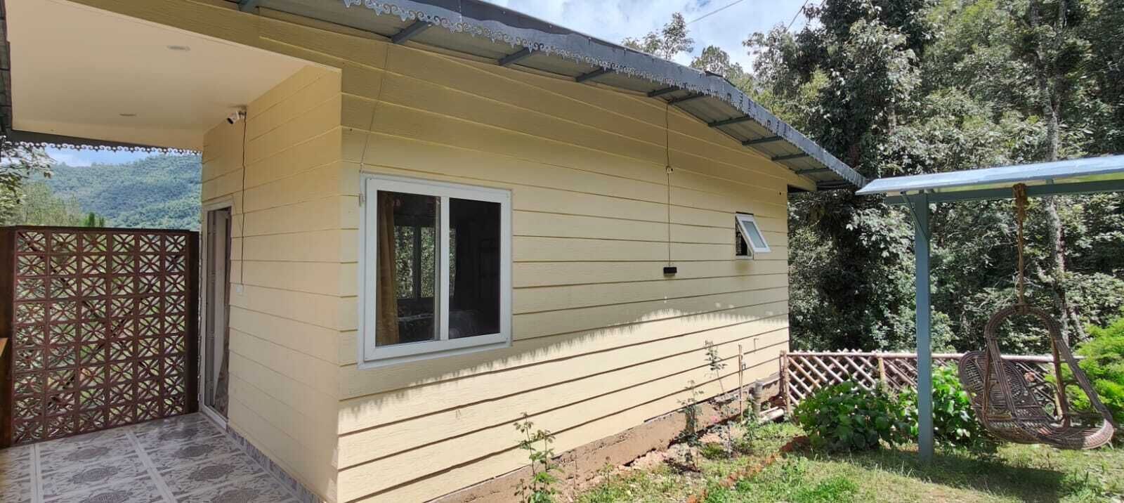 A single-story building with a covered porch, a window, and a small door.