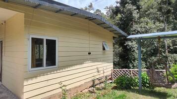 A single-story building with a covered porch, a window, and a small door.
