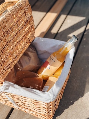 A wicker basket containing a bottle of wine and two chocolate bars. - Store Lærkegård (Allinge-Sandvig)
