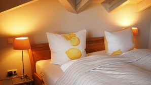 A bed with two pillows, a bedside lamp, and a nightstand with a lamp. - Vacation home with 3 separate bedrooms, 160 square meters (Truchtlaching)