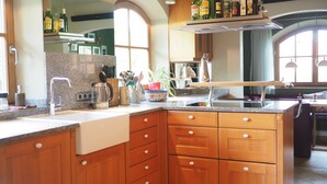 A kitchen with granite countertops, wooden cabinets, a built-in oven, and a window providing natural light. - Vacation home with 3 separate bedrooms, 160 square meters (Truchtlaching)