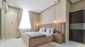 A modern bedroom with a large bed, bedside tables, a wardrobe, and pendant lighting. - Cozy 3 Bedroom Apartmen -Swimming Pool & Gym QQ (Lagos)