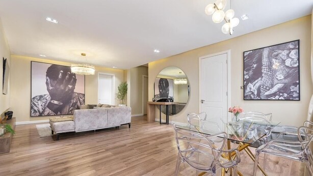 A spacious living area with a sofa, a dining table with chairs, and artwork on the walls. - Cozy 3 Bedroom Apartmen -Swimming Pool & Gym QQ (Lagos)