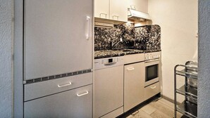 A kitchen with a built-in oven, microwave, and a stove. - Paradies 001 Appartement/Fewo, Bad, WC, 6-Bettwohnung 6-Bettwohnung by Interhome (Arosa)
