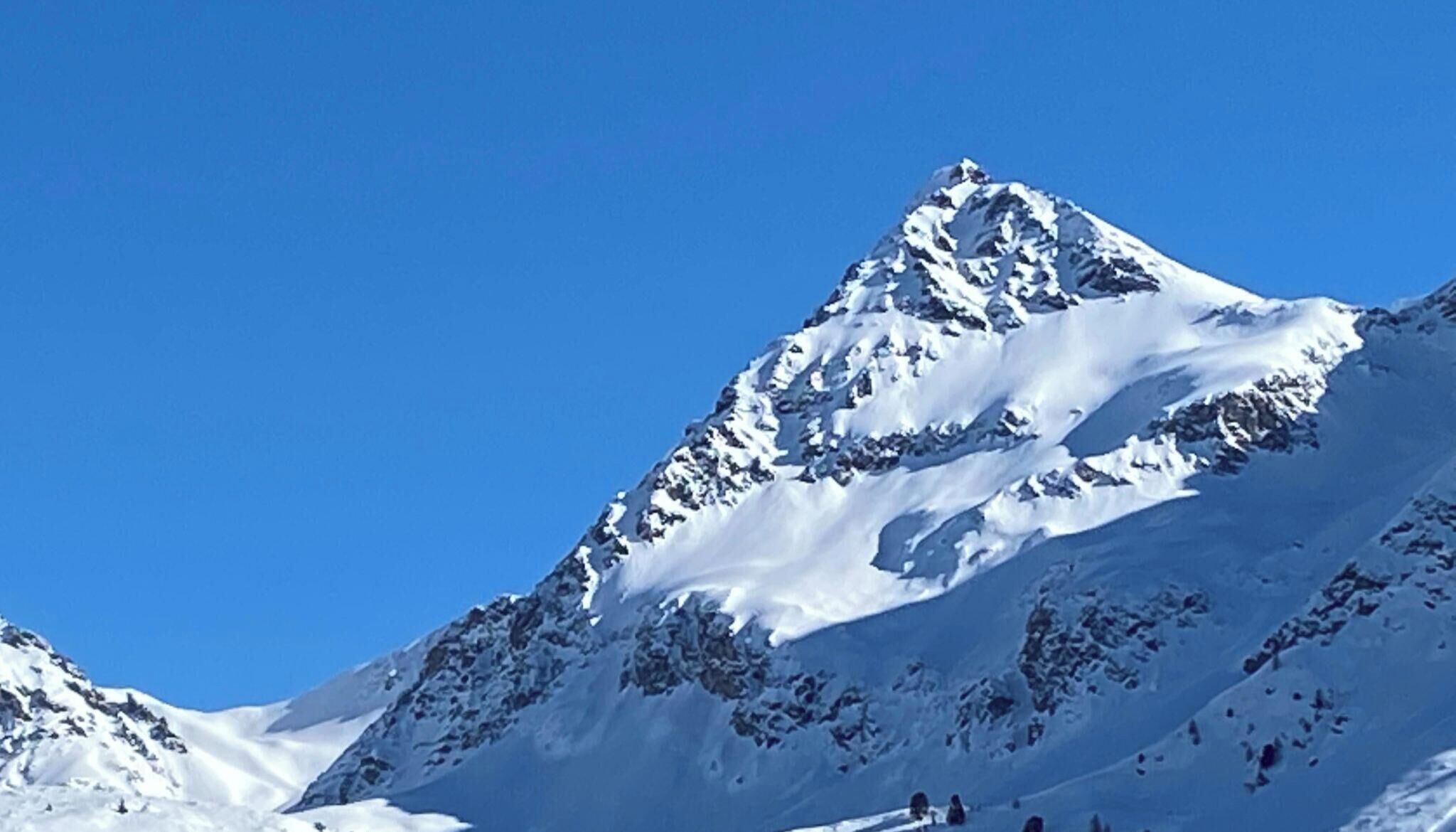 A snow-covered mountain peak with clear skies.