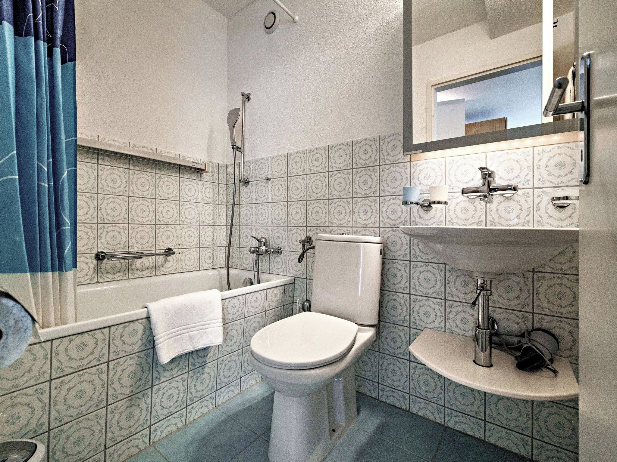 A bathroom with a toilet, sink, and bathtub.