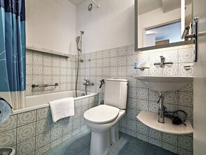 Un baño con inodoro, lavamanos y bañera.