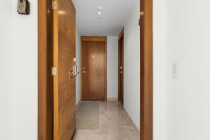 Ein Korridor mit Holztüren, einem Teppich und einem Lichtschalter an der Wand.