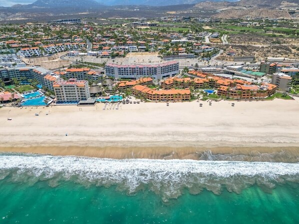 Une station balnéaire dotée de logements situés en bord de mer, d’une piscine et d’une plage.