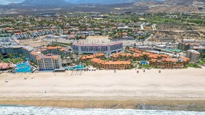 An aerial view of a coastal resort with beachfront properties, a sandy beach, and a clear view of the ocean. - Bright and comfortable lock-off suite in Vista La Jolla featuring a king bed, private entrance, full bathroom, mini-fridge, microwave, coffee station, and high-speed Wi-Fi. Just minutes from Costa Azul Beach, dining, shopping, golf, and downtown SJC. (San José del Cabo)