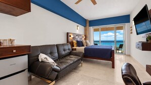 A modern hotel room with a leather sofa, a bed, a desk, and a TV. - Bright and comfortable lock-off suite in Vista La Jolla featuring a king bed, private entrance, full bathroom, mini-fridge, microwave, coffee station, and high-speed Wi-Fi. Just minutes from Costa Azul Beach, dining, shopping, golf, and downtown SJC. (San José del Cabo)