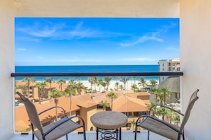 Un balcó amb vista a una platja i palmeres.