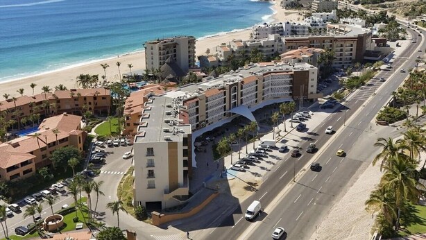 A coastal hotel with multiple buildings, a beach, and a road with vehicles. - Bright and comfortable lock-off suite in Vista La Jolla featuring a king bed, private entrance, full bathroom, mini-fridge, microwave, coffee station, and high-speed Wi-Fi. Just minutes from Costa Azul Beach, dining, shopping, golf, and downtown SJC. (San José del Cabo)