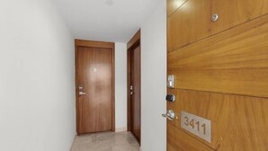 A hallway with a wooden door marked 'B' and a wooden paneling wall with a number plate '3411'. - Vista La Jolla 408B | King Suite Minutes from Costa Azul Beach (San José del Cabo)