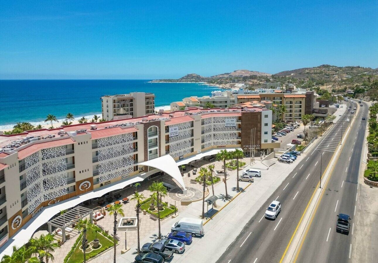 A coastal hotel with a beachfront view, multiple parking levels, and a prominent white architectural feature.