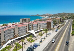 A coastal hotel with a beachfront view, multiple parking levels, and a prominent white architectural feature.