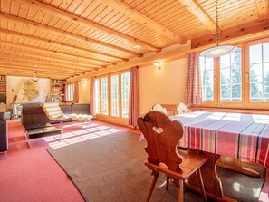A wooden interior with a dining table, chairs, a sofa, and a bookshelf. - Chalet Soldanella by Arosa Holiday Appartement/Fewo, Dusche oder Bad, WC, 9-Bett by Interhome (Arosa)