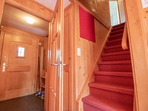 A wooden interior with a staircase, a door, and a red mat on the wall. - Chalet Soldanella by Arosa Holiday Appartement/Fewo, Dusche oder Bad, WC, 9-Bett by Interhome (Arosa)