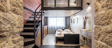 A modern interior with a staircase, a bed, and a desk area.