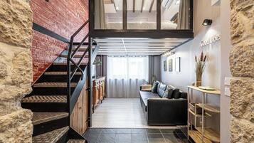 Un interior moderno con una escalera, un sofá y un comedor.