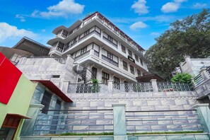 Ein mehrstöckiges Gebäude mit Balkonen, einer Treppe und einem verschlossenen Eingang.