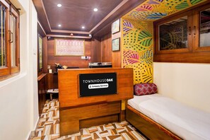 Ein Zimmer mit einem Bett, einem Empfangstresen mit der Aufschrift 'TOWNHOUSE OAK' und einer Wand mit Muster.