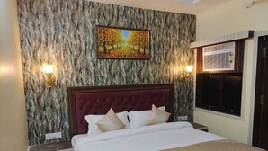 A bedroom with a marble-patterned wall, a large bed with a red headboard, two bedside lamps, and a window with blinds.