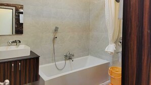 A modern bathroom with a bathtub, shower, and vanity.