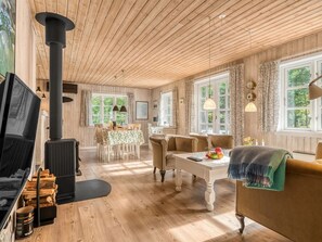 A cozy living room with a fireplace, wooden floors, and large windows. - "Alivia" - 500m from the sea by Interhome (Læsø)