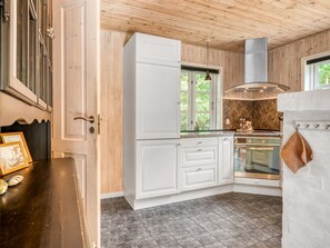 A kitchen with white cabinets, a stove, and a window. - "Alivia" - 500m from the sea by Interhome (Læsø)
