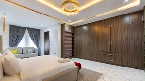 Een moderne slaapkamer met een groot bed, een garderobe en een kroonluchter.