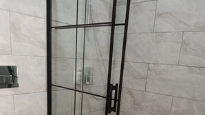 A bathroom with a glass-enclosed shower, a white toilet, and marble tiles. - Therapy Igloo (Bodrum)